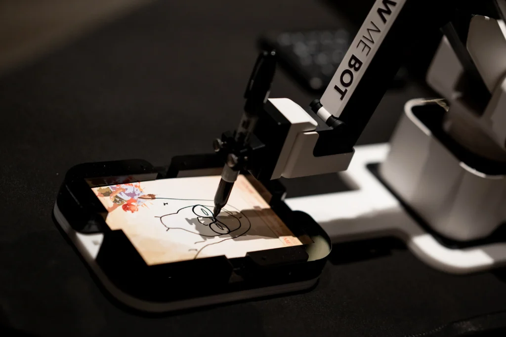 Robotic drawing arm creating a live sketch portrait during an event